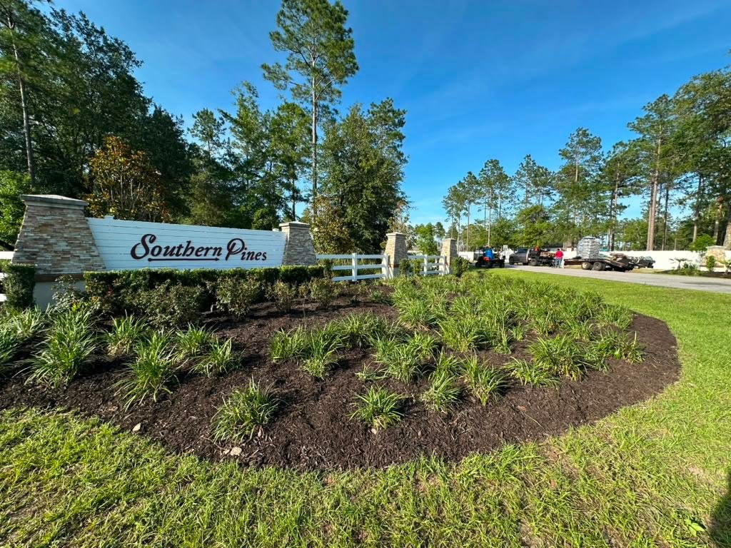 Seasonal commercial flower bed with red and gold annuals at a property entrance