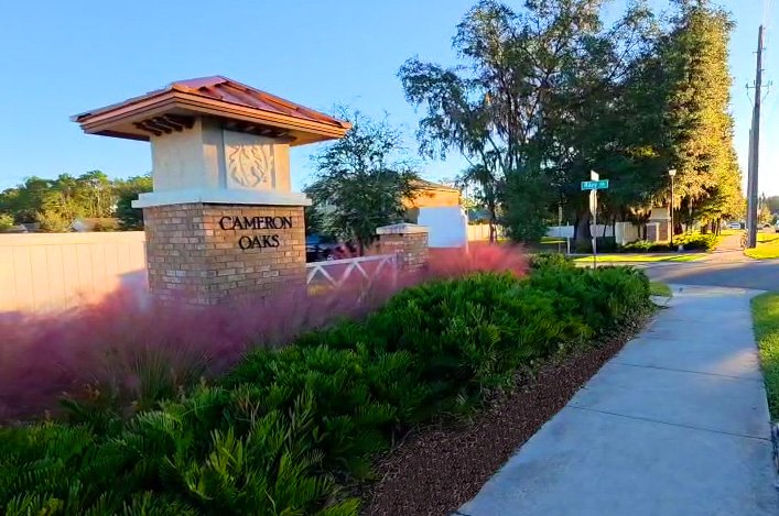 HOA entrance monument framed by ornamental muhly grass and clean shrub beds